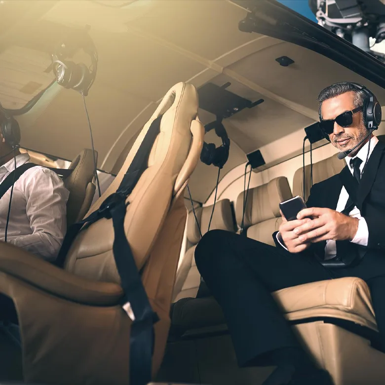 mature businessman using a mobile phone while traveling in a helicopter